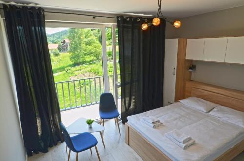 a bedroom with a bed and a large window at Apartament RELAKS w spokojnej okolicy - SUN&SPORT in Szczyrk