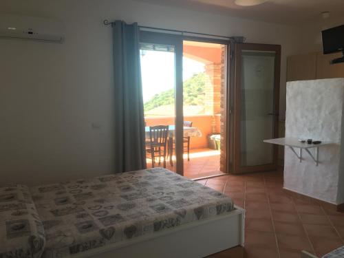 a bedroom with a bed and a door to a balcony at TERRAZZA SUL MARE wifi e piscina in Nebida