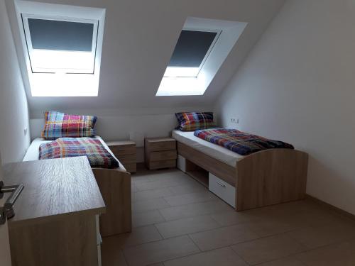 a small room with two beds and two skylights at Apartment Geiger in Donzdorf