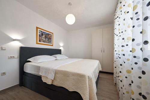 a bedroom with a large bed and a curtain at SUNNY SIDE in Trogir