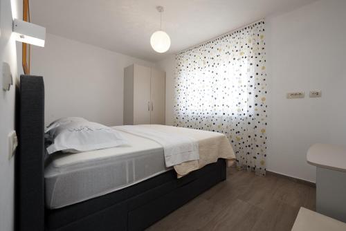 a white bedroom with a bed and a bathroom at SUNNY SIDE in Trogir