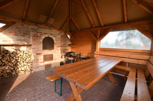 ロビにあるDomki na Różanej 2の暖炉付きの部屋(大きな木製テーブル付)