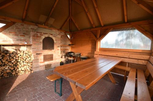 a large wooden table in a room with a fireplace at Domki na Różanej 2 in Rowy