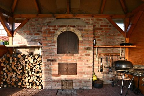 a brick oven with a pile of fire wood at Domki na Różanej 2 in Rowy