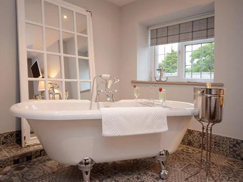 a white bath tub in a bathroom with a window at Tomahawk Steakhouse Ponteland in Ponteland