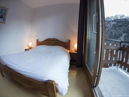 a bedroom with a bed and a balcony with a view at VAUJANYLOCATIONS - Chalet De Marie in Vaujany