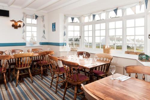 a restaurant with wooden tables and chairs and windows at The Pulpit Inn in Portland