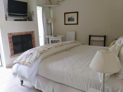 a bedroom with a white bed and a fireplace at Hotel Boutique Posada Piedras Blancas in Santa Rosa