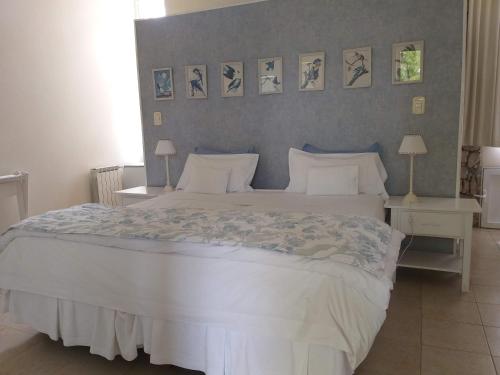 a bedroom with a large white bed with two tables and two lamps at Hotel Boutique Posada Piedras Blancas in Santa Rosa