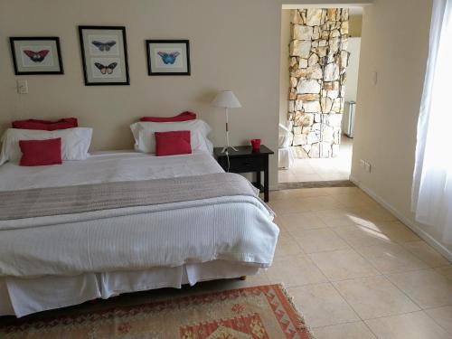 a bedroom with a large white bed with red pillows at Hotel Boutique Posada Piedras Blancas in Santa Rosa