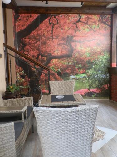 a table and chairs with a painting on the wall at Apartman Rustik in Belgrade