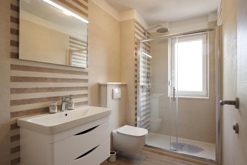 ein Bad mit einem Waschbecken, einem WC und einer Dusche in der Unterkunft SUNNY SIDE in Trogir