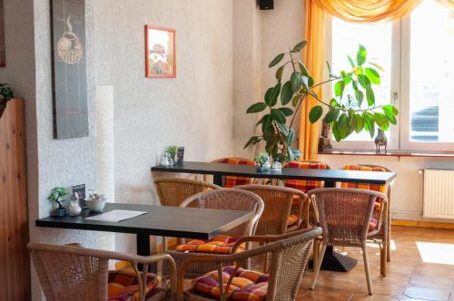 a dining room with tables and chairs and a plant at Landhaus Nauenburg in Heere