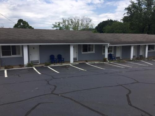 a building with two blue chairs in a parking lot at Hilltop Inn in Franklin