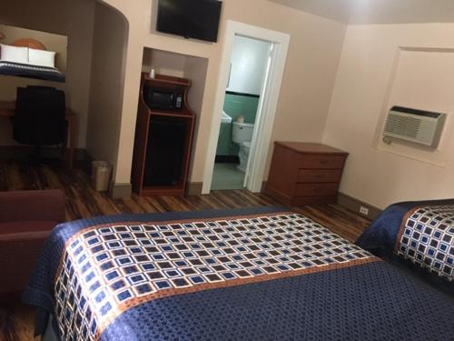 a hotel room with two beds and a bathroom at Hilltop Inn in Franklin