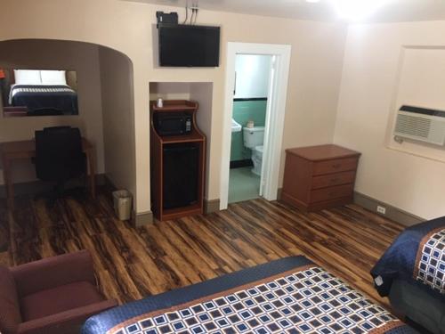 a room with a bedroom with a bed and a dresser at Hilltop Inn in Franklin