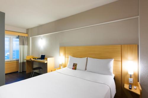 a hotel room with a large bed and a desk at ibis Fortaleza Praia de Iracema in Fortaleza