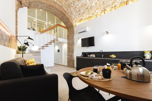 a kitchen and dining room with a table with a tea kettle at Casa Marene Ortigia in Siracusa