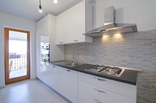a kitchen with white cabinets and a stove top oven at Josipa & Jelena Apartment in Senj