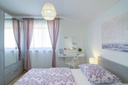 a bedroom with a bed and a desk in it at Josipa & Jelena Apartment in Senj