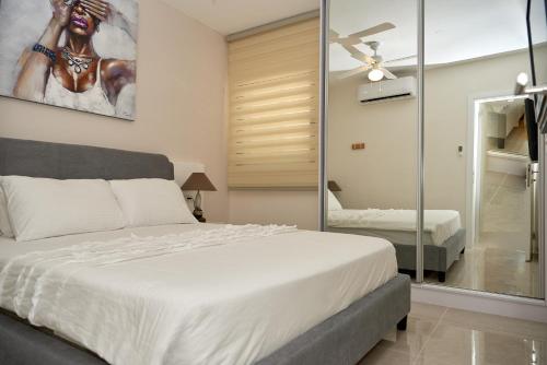a bedroom with a large white bed and a mirror at נוף לים האדום - sea view eilat in Eilat