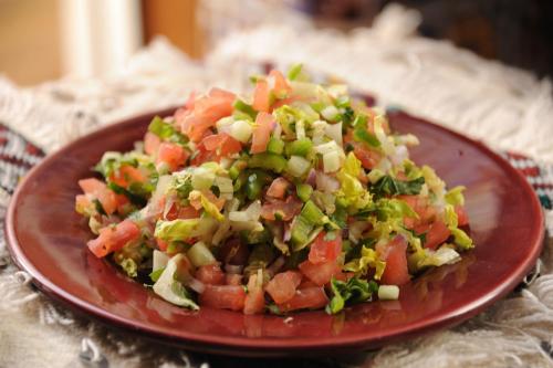 a red plate with a salad on a table at Riad Shaden in Marrakech