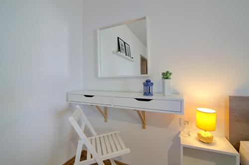 einen weißen Schminktisch mit einem Spiegel und einem Stuhl in der Unterkunft Josipa & Jelena Apartment in Senj
