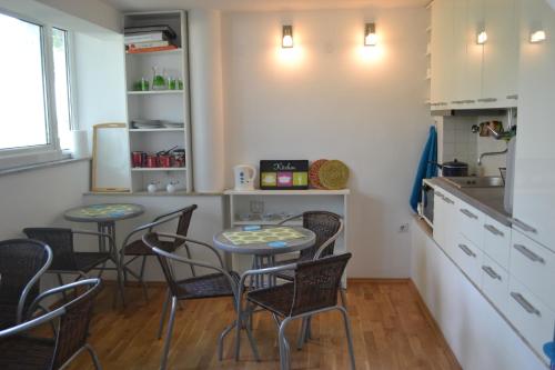 a kitchen with four chairs and a table in a kitchen at Guesthouse Liska in Mostar