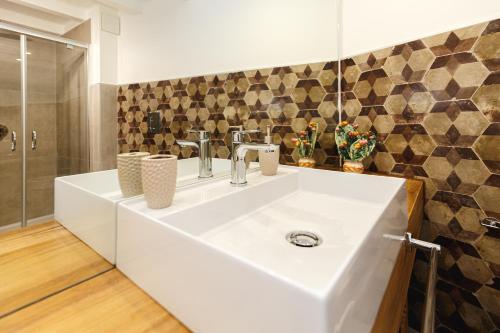 a bathroom with a white sink and a shower at Casa Marene Ortigia in Siracusa