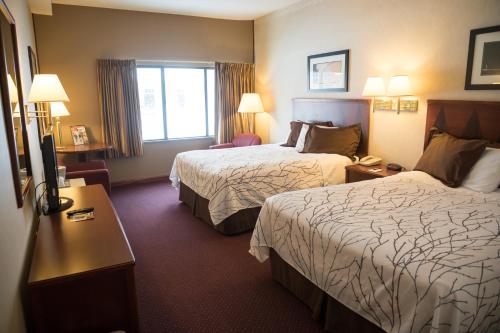 a hotel room with two beds and a window at Mineral Palace Hotel & Gaming in Deadwood