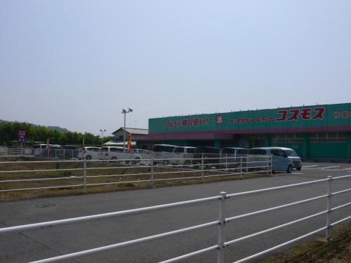a parking lot with cars parked in front of a building at Guesthouse RETURN in Kitsuki