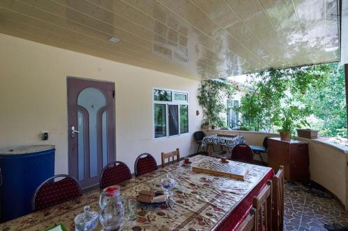 una sala da pranzo con tavolo, sedie e finestra di Ancient Lahij Guest House a Lahıc