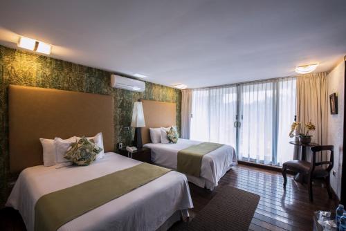 a hotel room with two beds and a window at Colombe Hotel Boutique in Xalapa