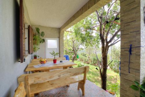 a wooden table and bench in a room with a tree at Josipa & Jelena Apartment in Senj