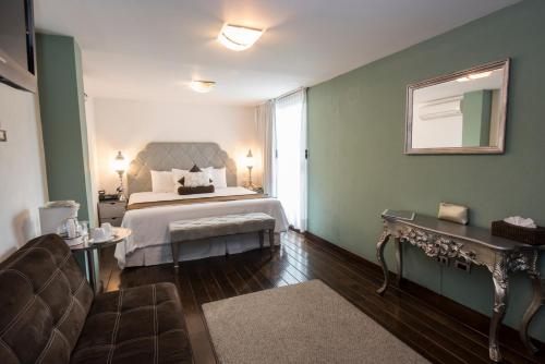 a hotel room with a bed and a couch at Colombe Hotel Boutique in Xalapa