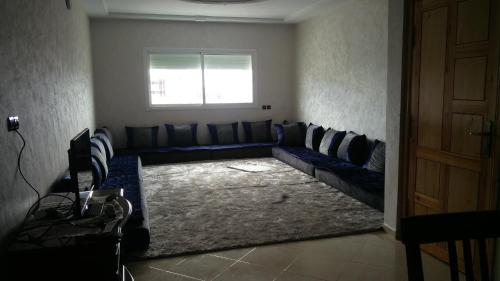 a living room with a couch and a window at LOGEMENT HOTEL et NAVETTE GRATUITE in Fès