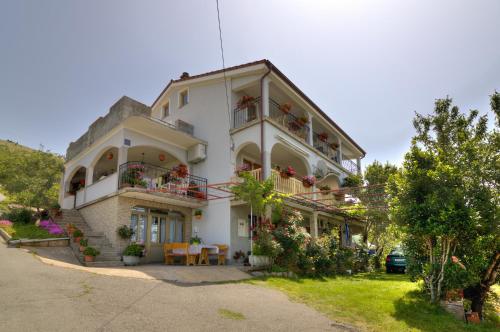 a large white building with flowers on the balconies at Josipa & Jelena Apartment in Senj