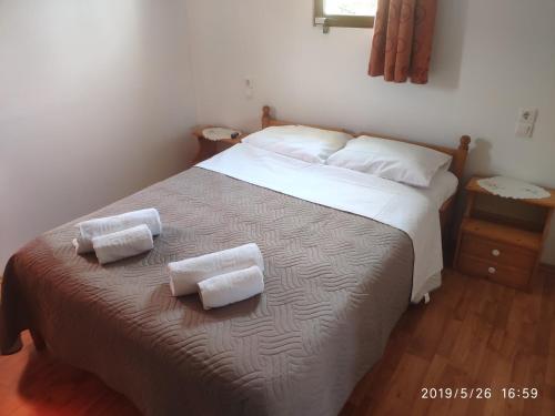 a bedroom with a bed with two towels on it at Green Farm-small paradise! in Kalloní