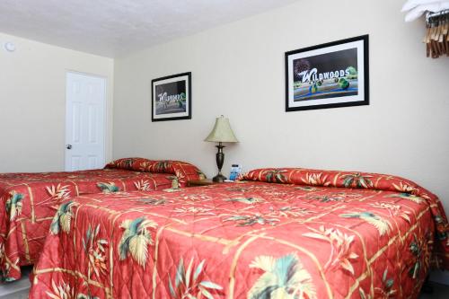 a bedroom with two beds with a red bedspread at Stardust Motel in Wildwood