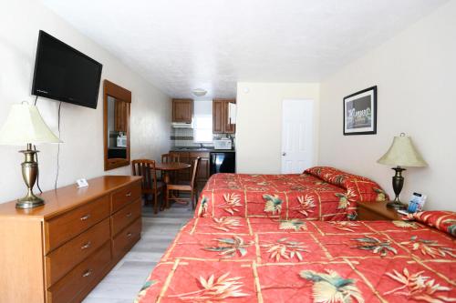 a hotel room with two beds and a flat screen tv at Stardust Motel in Wildwood