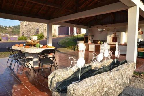 a patio with a table and chairs under a pavilion at Casa da Torre luxury villa in Braga in Braga