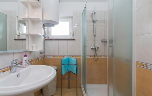 uma casa de banho com um lavatório e um chuveiro em Seafront apartment Gaby em Medulin