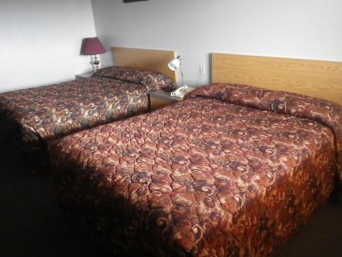 a bedroom with two beds in a hotel room at Alcan Motor Inn in Haines Junction