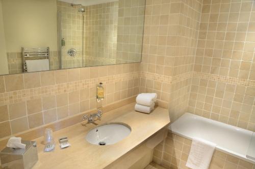 a bathroom with two sinks and a mirror at Inglewood Manor in Ledsham