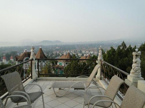a balcony with chairs and a view of a city at Eton Asia Villas-Kota Bunga in Puncak