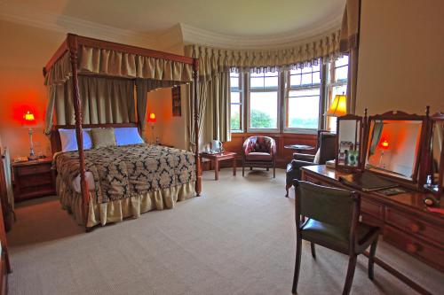 a bedroom with a bed and a desk and a television at Ramnee Hotel in Forres