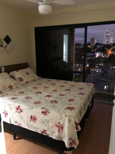 a bedroom with a bed with pink flowers on it at Apartamento Top Morumbi in São Paulo