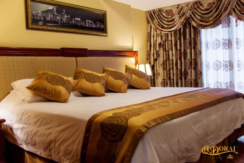 1 dormitorio con 1 cama grande con almohadas amarillas en Apart Hotel El Doral, en Lima
