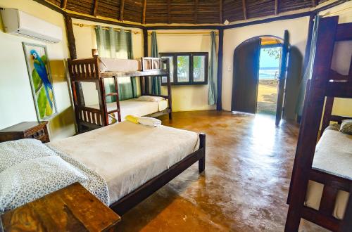 a room with two bunk beds and an open door at Hotel Oasis & Surf Camp in Santa Catalina