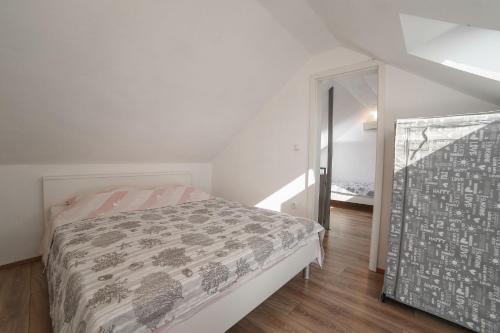 een witte slaapkamer met een bed en een spiegel bij Villa Baras garden - house with pool in Mirce
